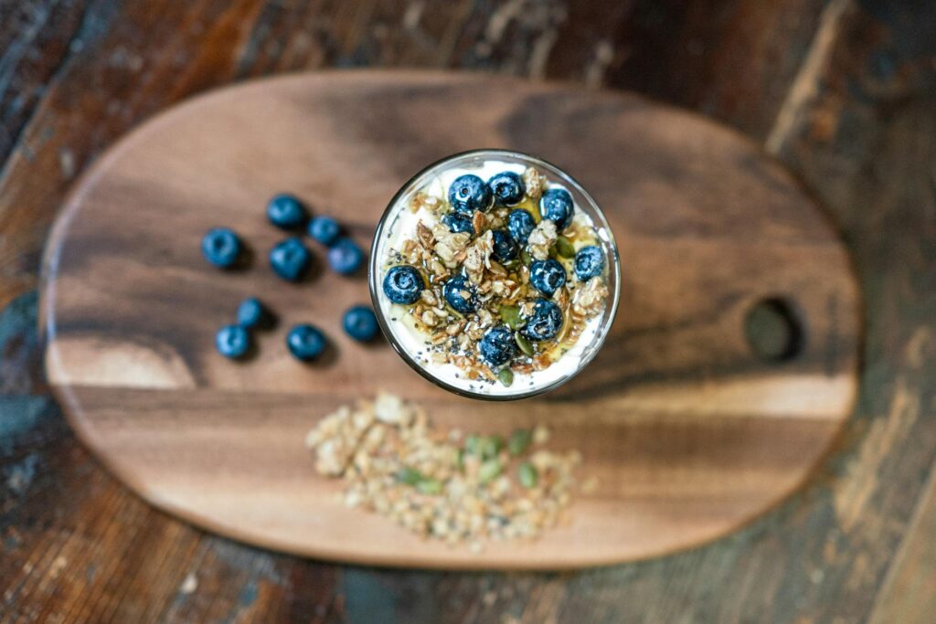 Top view of a nutritious granola parfait with fresh blueberries in a glass bowl, perfect for a healthy snack.